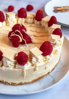 a cheesecake with raspberries on top sits on a plate