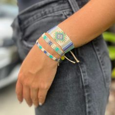 a close up of a person's arm wearing bracelets with beads on it