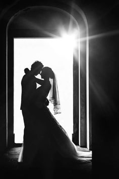 a bride and groom standing in front of an open door at the end of their wedding day