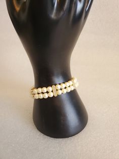 "Ladies look what I found! This beautiful 2 rows of beige buttery faux pearls bracelet. It has gold tone metal findings that include a slide in box clasp, so it is vintage but if you look at it closely is in mint condition. The stations elevate it make it look like it expensive. I recently purchased a jewelry box at an Estate Sale that had lots of jewelry in it. This one was part of that jewelry. All clear rhinestones are intact with non-missing. If you see the runway this year, it's all about p Elegant Adjustable Cream Pearl Bracelet, Elegant Beaded Cream Bracelets, Vintage Gold Beaded Bracelets, Cream Colored Bracelet For Formal Occasions, Cream Bracelet For Formal Occasions, Elegant Adjustable Cream Beaded Bracelets, Cream Colored Formal Bracelet Jewelry, Cream Formal Bracelet Jewelry, Elegant Cream Beaded Pearl Bracelet