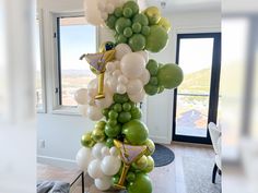 a bunch of green and white balloons on a pole