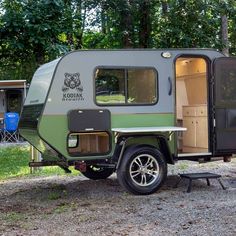 an rv parked in the gravel with its door open