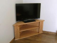 a flat screen tv sitting on top of a wooden stand