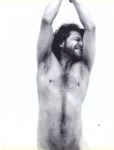 a shirtless man holds his hands up in the air while standing against a white background