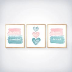 three watercolor hearts are hanging on the wall in front of two framed art pieces