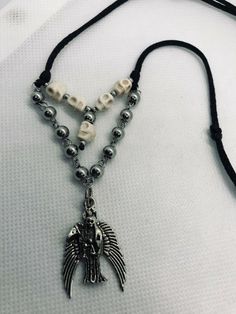 "Dije de la Santa Muerte Plateada con bolas de acero inoxidable platada y craneo blanca terminado en collar con hilo de cordon grueso negro Collar ajustable con cierre minimo desde 16\" pulgadas como collar gargantilla y expandible hasta 28\" pulgadas como collar Material: Santa Muerte plateada con alas Metal rustico 3 cm craneo blanca 6mm bolas de acero inoxidable plateada 6mm, 3mm con cadena de acero inoxidable hilo de cordon grueso color negro Personalizamos el color del cordon, preguntenos!! Silver Skull Stainless Steel Jewelry, Silver Stainless Steel Skull Jewelry, Adjustable Silver Punk Jewelry, Skull Shaped Silver Jewelry For Festival, Silver Skull Shaped Festival Jewelry, Silver Skull Jewelry For Festivals, Silver Adjustable Skull Necklace, Adjustable Silver Skull Necklace, Designer Wishlist