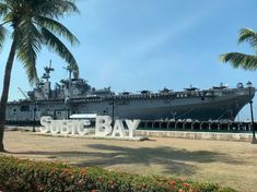 a large ship sitting in the water next to a sign that says sutc bay