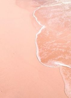 two people walking on the beach with their surfboards