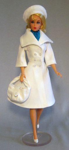 a barbie doll wearing a white coat and hat