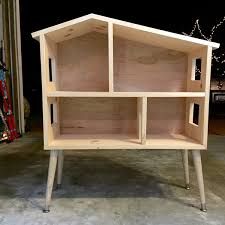 a wooden shelf sitting on top of a cement floor next to a building with lights in the background