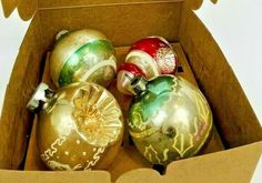 a cardboard box filled with assorted christmas ornaments