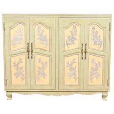 an ornate white cabinet with gold and silver designs on the doors, side panels and drawers