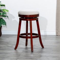 a wooden stool sitting next to a potted plant