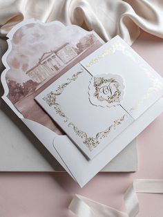 a wedding card with an ornate design on the front, and a ribbon tied around it