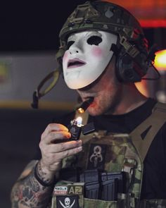 a man wearing a mask and holding a lighter