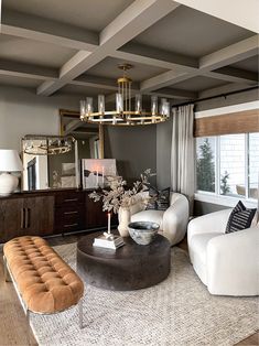 a living room filled with furniture and a chandelier hanging over the top of it