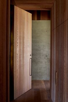 an open door leading into a room with wood floors and walls on either side of it