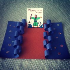 there is a book about moses and the red sea with blue plastic blocks in front of it