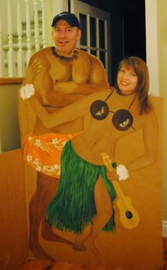 a woman standing next to a man in a hula skirt on a cardboard board