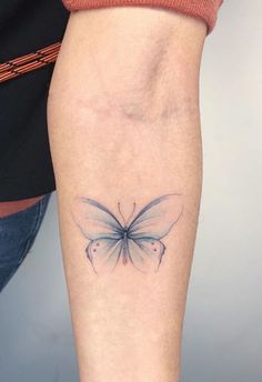 a woman's leg with a small butterfly tattoo on the left side of her calf