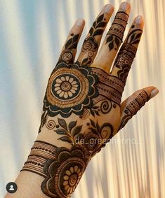 the hand is decorated with henna and flowers