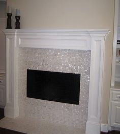 a white fireplace in a living room next to a book shelf