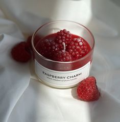 raspberry chaam in a small glass bowl on a white cloth with two raspberries