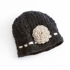 a crocheted hat with a flower on the front and white stitching around the brim