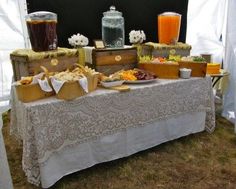 a table with food and drinks on it in front of a white tented area