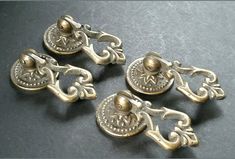 four antique brass door knobs with ornate designs