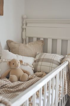 a teddy bear sitting on top of a bed in a room with pillows and blankets