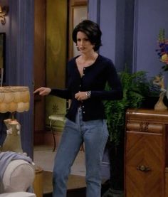 a woman standing next to a man in a living room on the set of friends