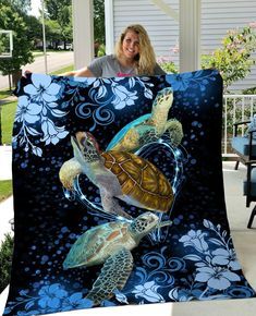 a woman holding up a blanket with two turtles on it