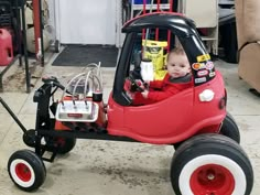 a small child in a red toy car