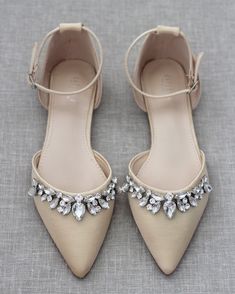 a pair of shoes with jeweled straps on the toes and heels are sitting on a gray surface