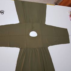 a piece of cloth is cut out to look like a doll's dress with holes in it