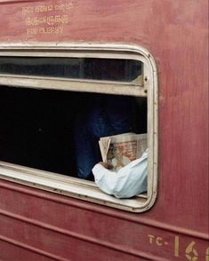 a person is looking out the window of a train car with paper on it's side