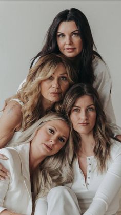 three women are posing for the camera with their arms around each other and looking at the camera