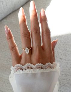 a woman's hand with a ring on it and lace around the middle of her fingers