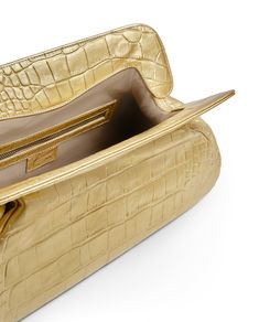 Maxi bag clutch with a feminine and versatile design.

 Gold cowhide with an embossed mock croc finish
 Magnet closure
 shoulder strap
 Gold-tone hardware
 Cotton satin lining with zipper pocket
 Made in Spain
 H19.5cm x W39cm x D12cm Designer Formal Bags With Textured Finish, Designer Formal Bag With Textured Finish, Luxury Formal Bags With Textured Finish, Chic Top Handle Bag With Textured Finish, Formal Gold Bag With Crocodile Pattern, Luxury Textured Leather Clutch For Office, Gold Clutch With Gold-tone Hardware For Office, Luxury Textured Leather Clutch Evening Bag, Leather Bag With Textured Finish For Evening