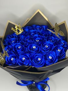 a bouquet of blue roses with gold butterflies