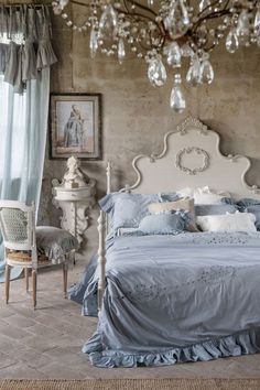 a bedroom with a bed and chandelier hanging from the ceiling