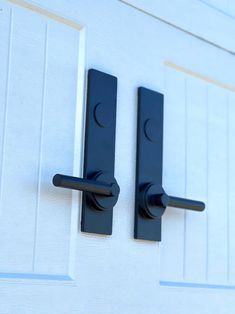 two black handles on a white door