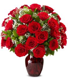 a vase filled with red roses and baby's breath