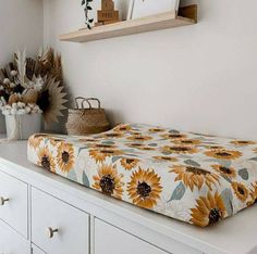 a sunflower print bed spread sitting on top of a dresser