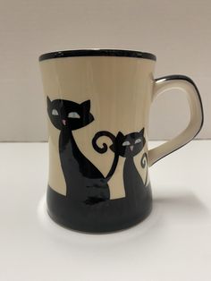 a black and white coffee cup with two cats on it