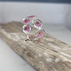 Flowers silver ring meticulously crafted using hand picked flowers and fully cured UV resin. The sterling silver handmade band is inspired by the graceful charm of Boho jewelry. This pink ring gift is a perfect meaningful gift for a beloved woman, and as a pampering gift for yourself. The jewelry is very flattering, lightweight, comfortable to wear as jewelry for everyday use and impressive as jewelry for a special occasion. Each piece is individually crafted to order, ensuring a unique touch, with subtle variations that make every piece truly one-of-a-kind. Elevate your style with this exceptional jewelry- a wearable piece of art designed for your enjoyment. Purchase now for an exquisite blend of nature and craftsmanship. Special Features: - Handmade with Natural pink Lobularia flowers, f Handmade Sterling Silver Petal Jewelry, Pink Sterling Silver Flower Ring For Gift, Pink Sterling Silver Flower Ring As Gift, Pink Flower Shaped Sterling Silver Ring, Pink Flower Sterling Silver Ring, Pink Flower-shaped Sterling Silver Ring, Sterling Silver Flower Ring In Pink, Delicate Pink Sterling Silver Rings, Silver Nature-inspired Open Flower Ring