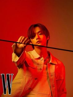 a young man is standing in front of a red background with the word w on it