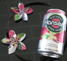 a can of canned drink with flower decorations on it's headband and hair clip