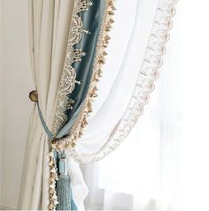 the curtains are hanging in front of the window with white drapes and blue trim